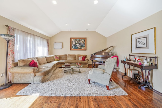 living room featuring vaulted ceiling, wood finished floors, and visible vents