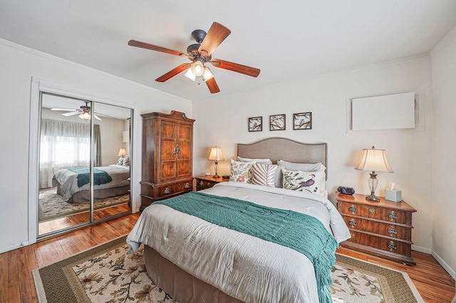 bedroom with a closet, wood-type flooring, ceiling fan, and crown molding