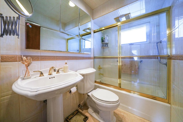 bathroom featuring tile patterned floors, toilet, tile walls, decorative backsplash, and bath / shower combo with glass door