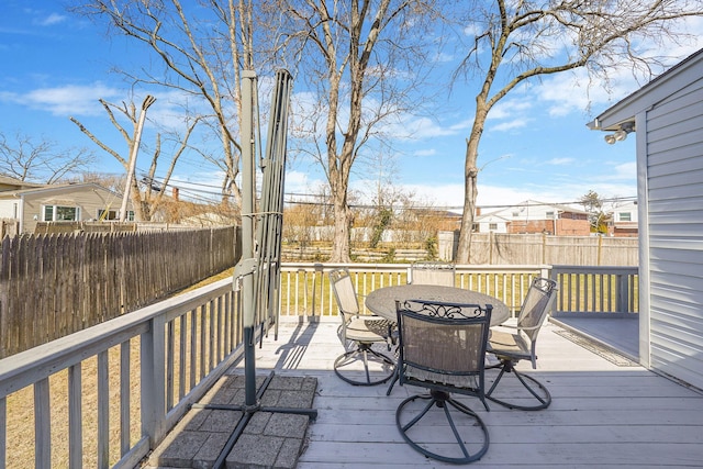 deck featuring outdoor dining space, fence, and a residential view