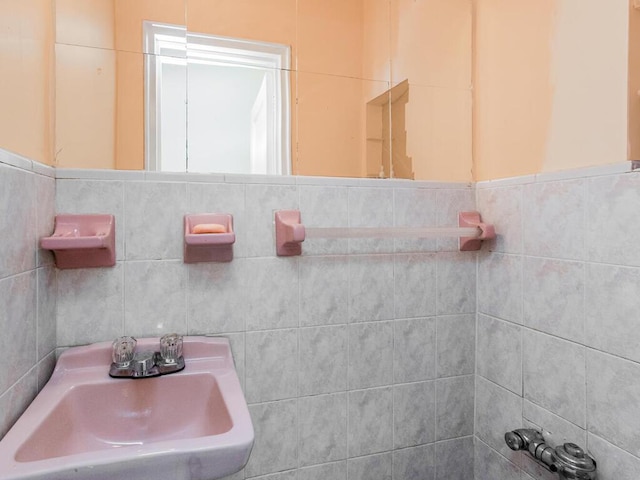 bathroom featuring a sink and tile walls