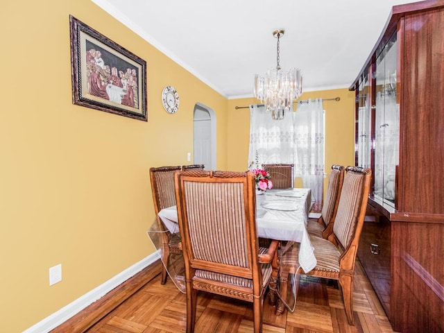 dining area featuring arched walkways, a notable chandelier, baseboards, and ornamental molding