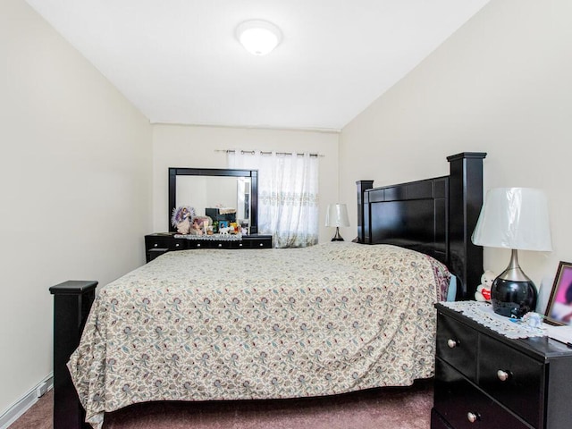 bedroom with dark carpet, baseboards, and vaulted ceiling