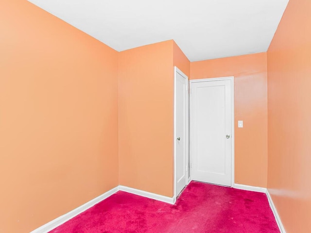 carpeted spare room featuring baseboards