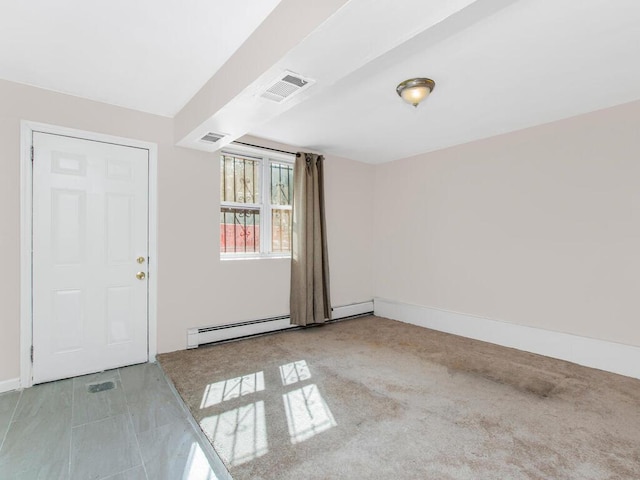 spare room with a baseboard heating unit, baseboards, and visible vents