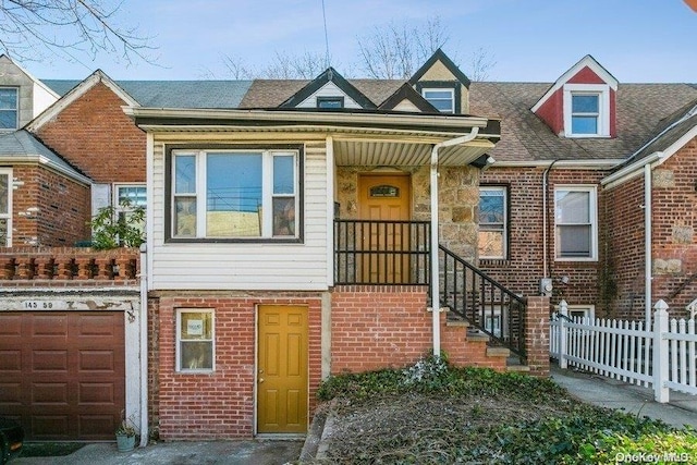 multi unit property featuring a garage, fence, and brick siding