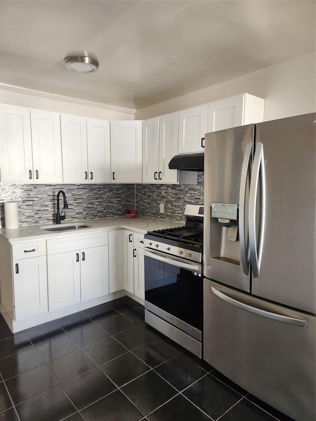 kitchen with under cabinet range hood, decorative backsplash, appliances with stainless steel finishes, and a sink