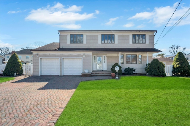 traditional-style home featuring decorative driveway, a front lawn, and fence