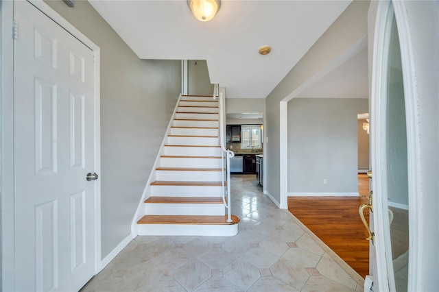 stairs with baseboards and tile patterned flooring