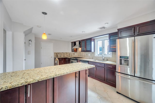 kitchen with glass insert cabinets, decorative backsplash, appliances with stainless steel finishes, wall chimney exhaust hood, and a sink