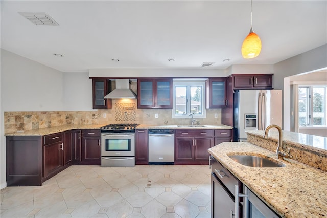 kitchen featuring a sink, stainless steel appliances, visible vents, and wall chimney range hood