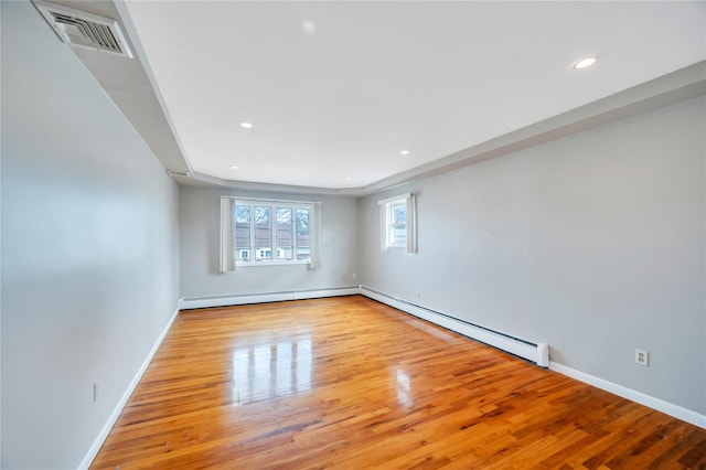 empty room with visible vents, baseboards, baseboard heating, recessed lighting, and wood finished floors