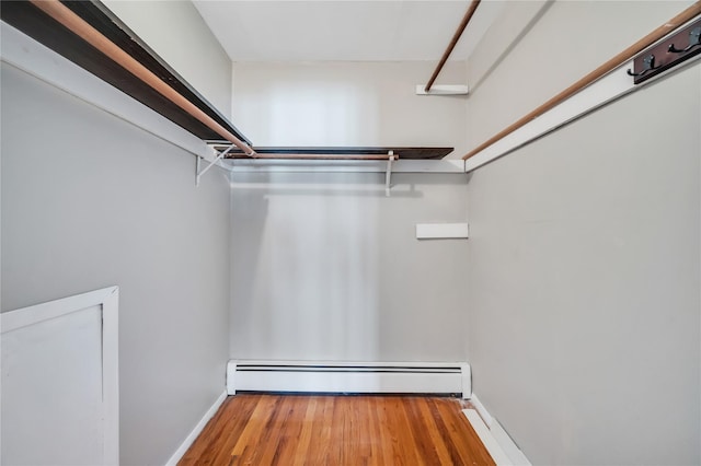 walk in closet featuring wood finished floors and baseboard heating