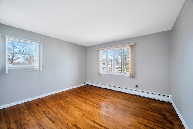 spare room with hardwood / wood-style flooring, a wealth of natural light, and baseboard heating