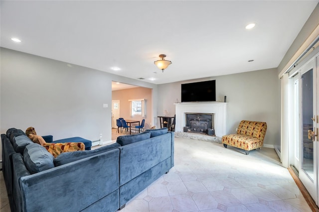 living room with recessed lighting, a baseboard heating unit, and baseboards