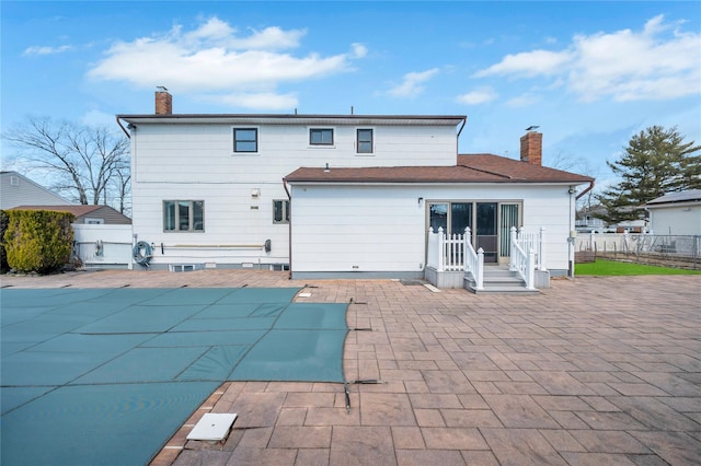 back of property featuring a patio, fence, and a chimney