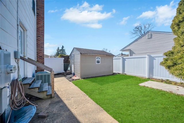 view of yard with an outbuilding, fence, a shed, and a patio area