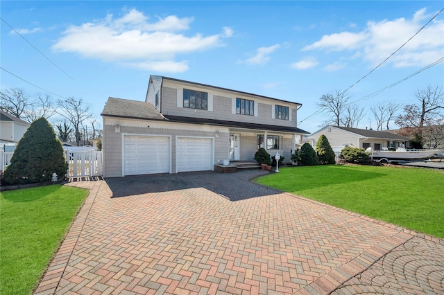 traditional home with fence, a front yard, covered porch, decorative driveway, and a garage