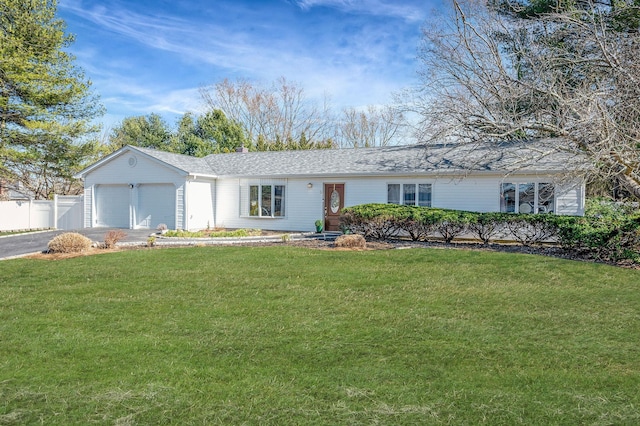 ranch-style house with aphalt driveway, an attached garage, fence, and a front yard