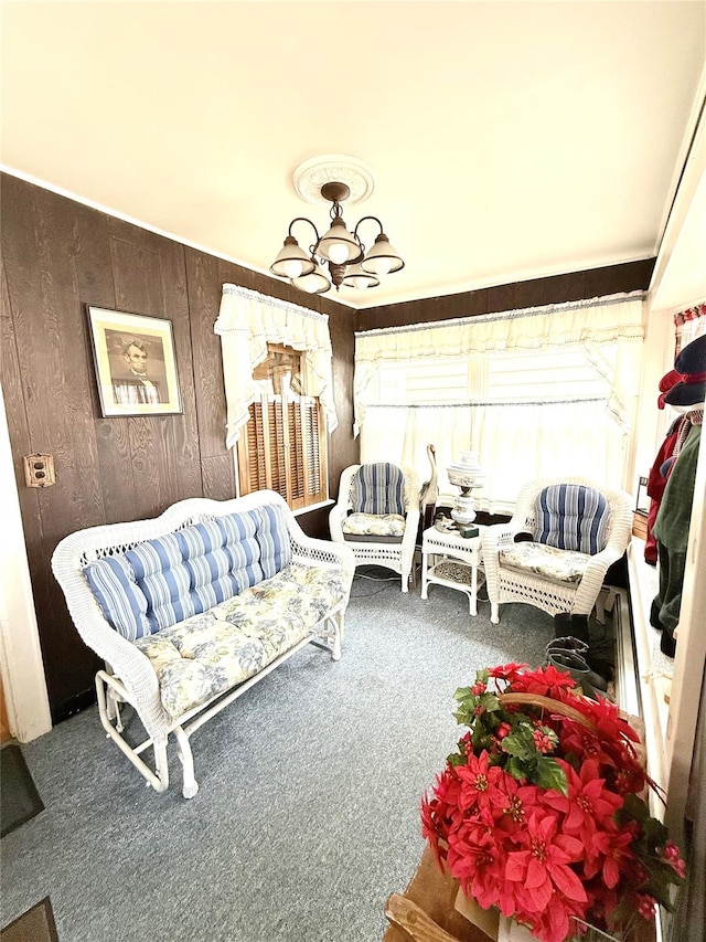 carpeted living area with wooden walls and an inviting chandelier