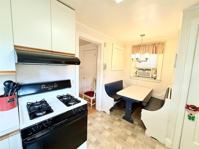 kitchen featuring pendant lighting, under cabinet range hood, range with gas cooktop, cooling unit, and a chandelier