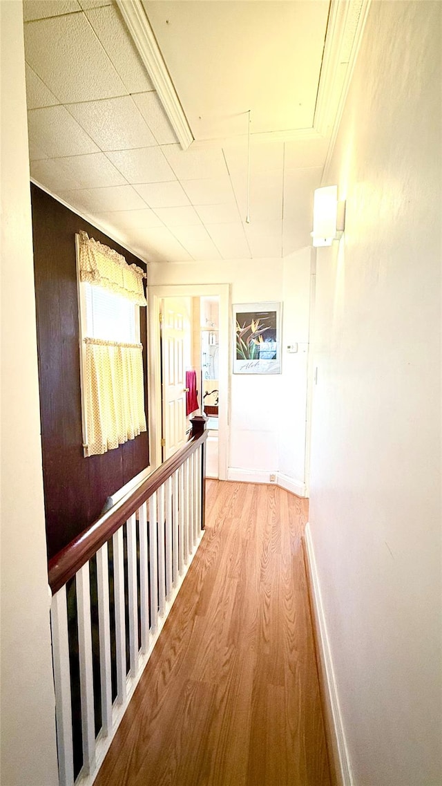 hall with attic access, baseboards, and wood finished floors