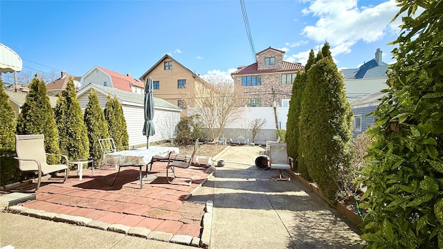 view of patio / terrace with an outdoor structure and fence