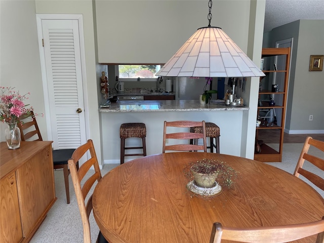 dining area with baseboards and a textured ceiling