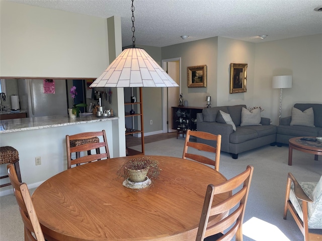 dining area with light carpet and a textured ceiling