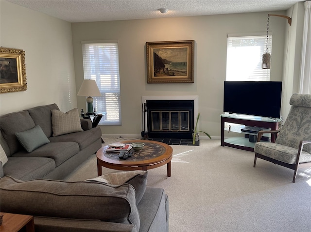 carpeted living room featuring a fireplace with flush hearth, a textured ceiling, and baseboards