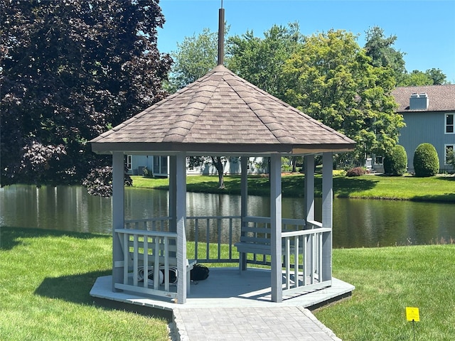 exterior space with a gazebo, a water view, and a lawn