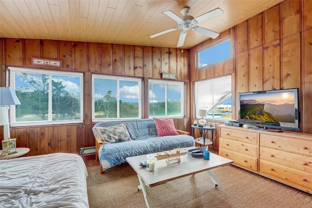 carpeted living area featuring wooden walls, a healthy amount of sunlight, wooden ceiling, and baseboard heating