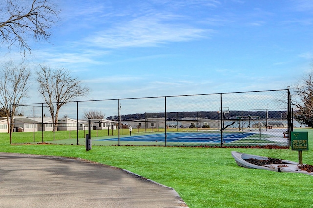 view of sport court featuring a yard and fence