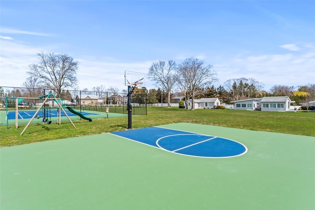 view of basketball court featuring playground community, a lawn, community basketball court, and fence