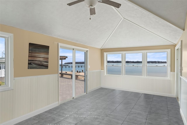 unfurnished sunroom featuring ceiling fan, lofted ceiling, and a water view