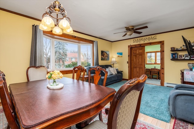 dining room featuring crown molding, baseboards, ceiling fan with notable chandelier, wood finished floors, and a baseboard radiator