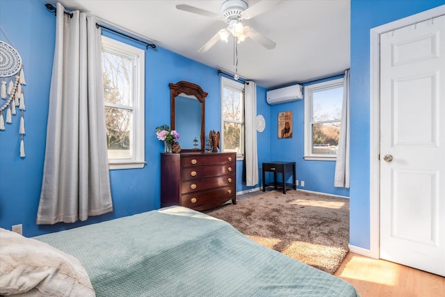 bedroom featuring baseboards, a ceiling fan, and a wall unit AC