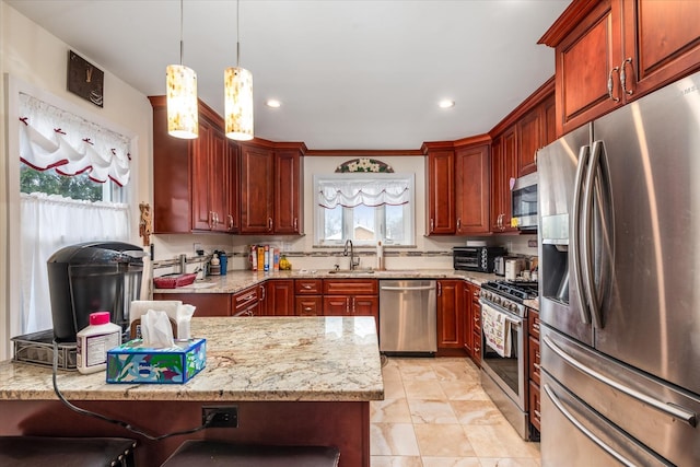 kitchen with pendant lighting, a sink, backsplash, stainless steel appliances, and light stone countertops