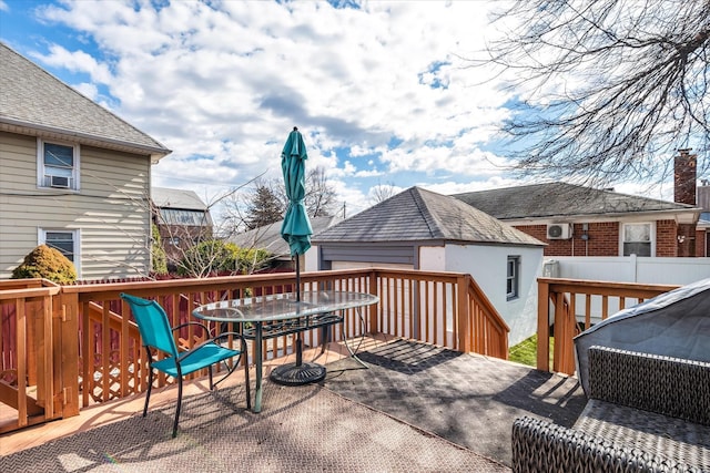 wooden deck with outdoor dining space, an outdoor structure, and fence