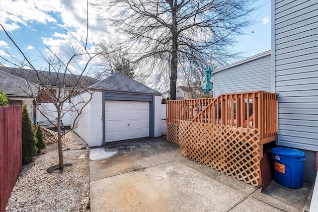 detached garage with concrete driveway and fence