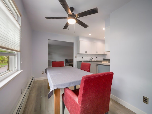 dining area with baseboard heating, light wood finished floors, baseboards, ceiling fan, and recessed lighting