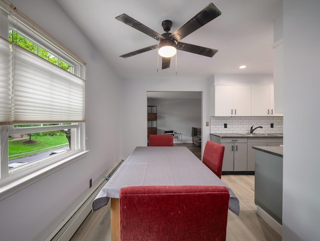 dining room with light wood-style floors, a ceiling fan, baseboard heating, and recessed lighting