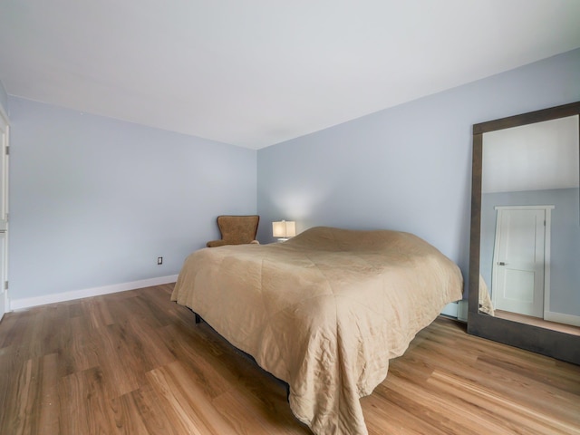 bedroom featuring wood finished floors and baseboards