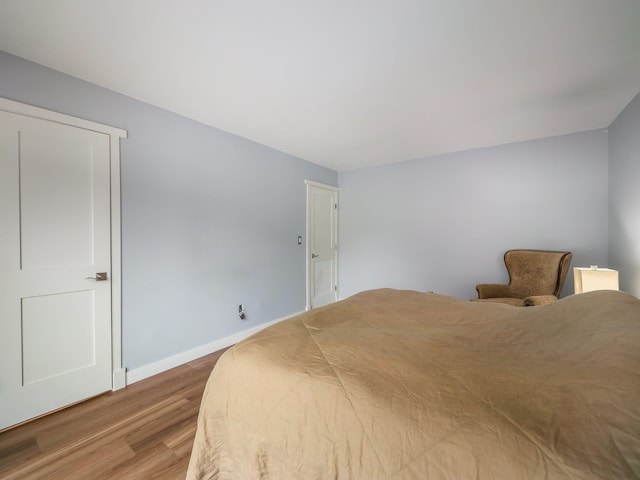 bedroom with wood finished floors and baseboards