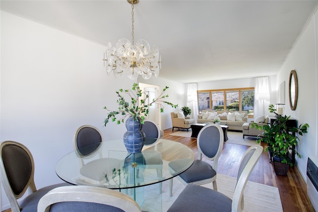 dining area with wood finished floors, baseboards, and a chandelier