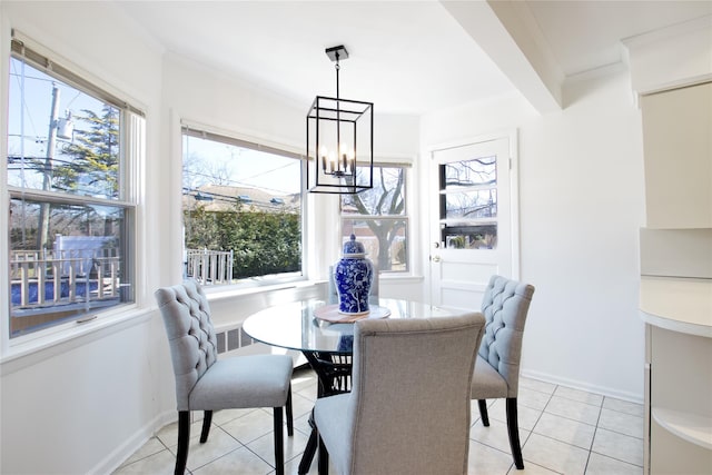 dining space featuring crown molding, a notable chandelier, light tile patterned floors, and baseboards