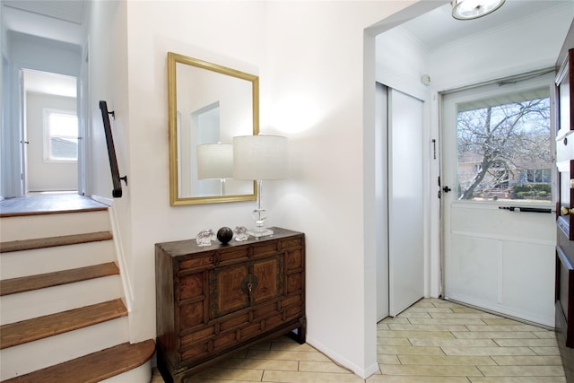 entrance foyer featuring stairway and crown molding