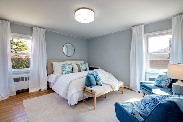 bedroom featuring radiator and wood finished floors