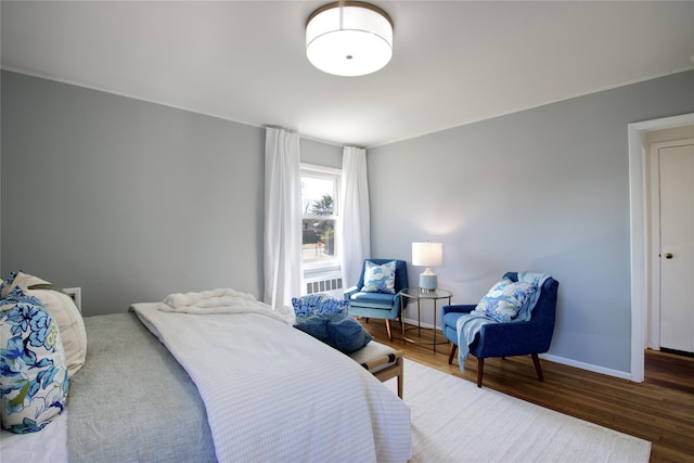 bedroom with baseboards and wood finished floors