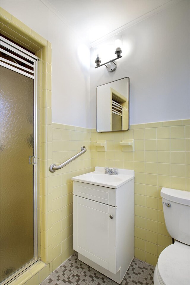 full bath with toilet, tile walls, and a stall shower